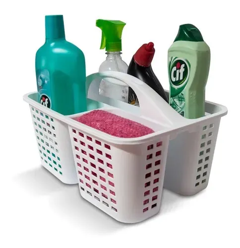 Cesta de plástico blanco para productos de limpieza que contiene botellas de spray, detergente y esponjas variadas sobre un fondo blanco.