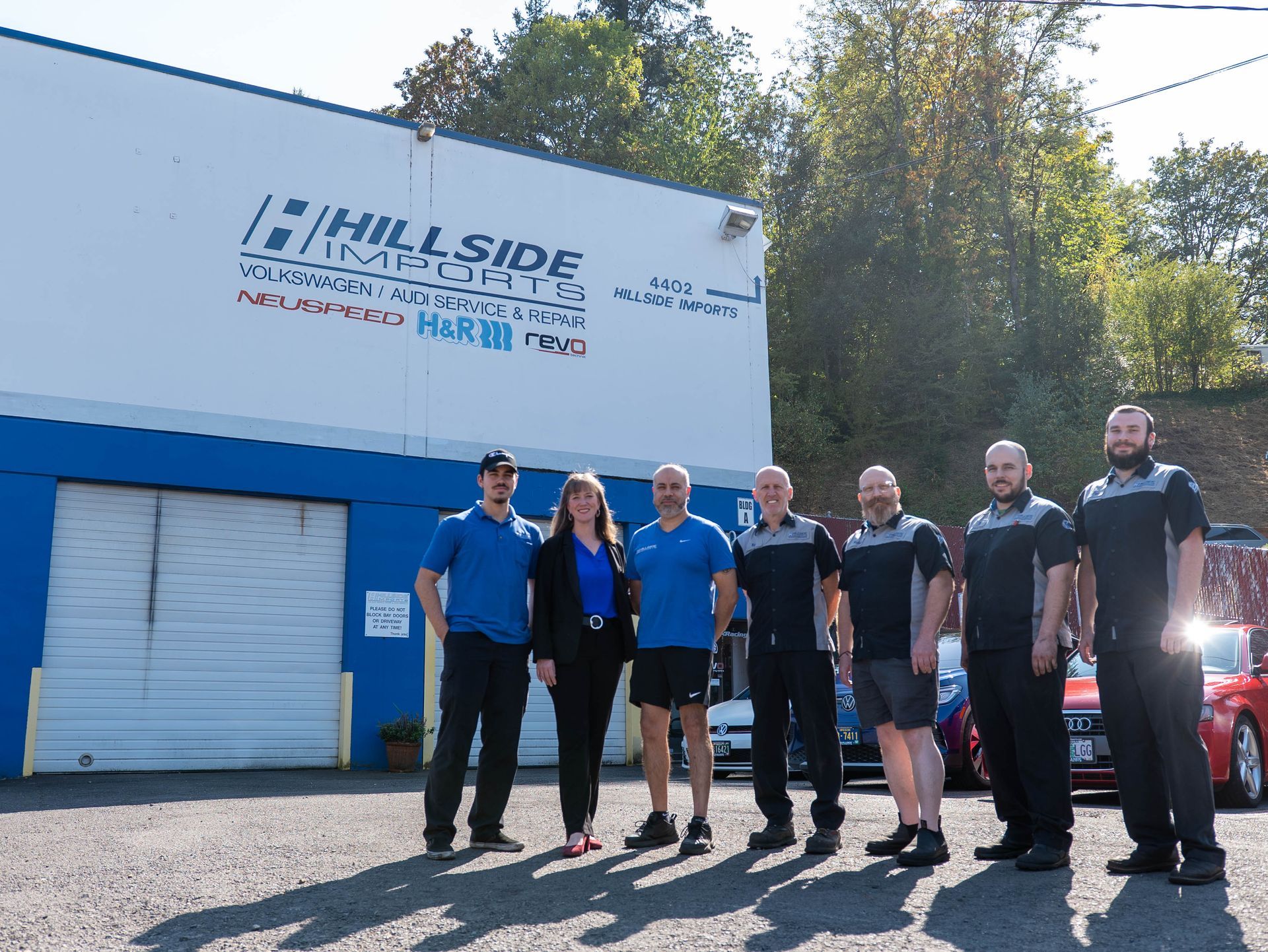 Group of mechanics posing outside of Hillside Automotive building.