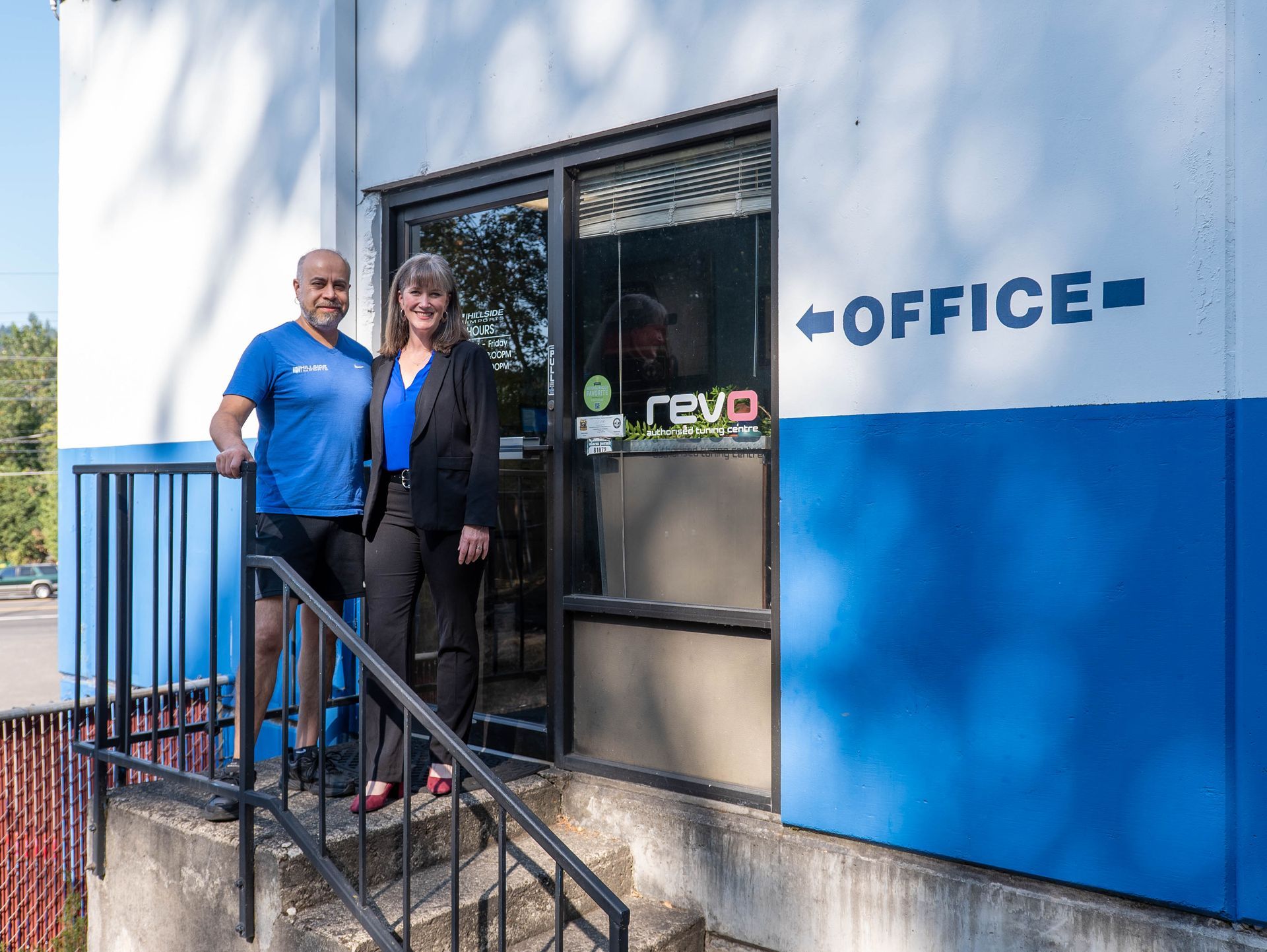 Two people stand outside a building marked 