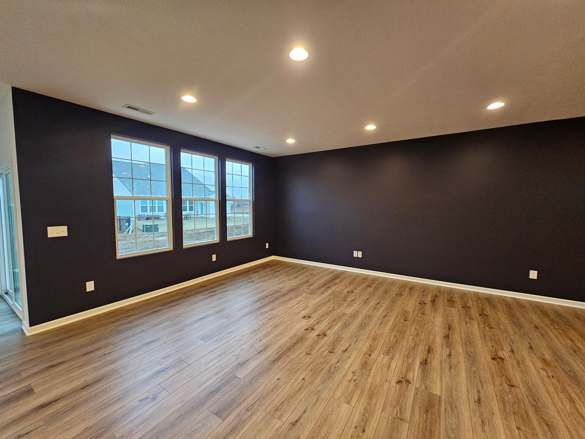 Modern Livingroom with dark navy painted walls and white trim – Grove City interior painting project. Promus Home Improvement