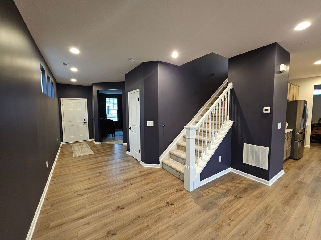 Modern entryway with dark navy painted walls and white trim – Grove City interior painting project. Promus Home Improvement