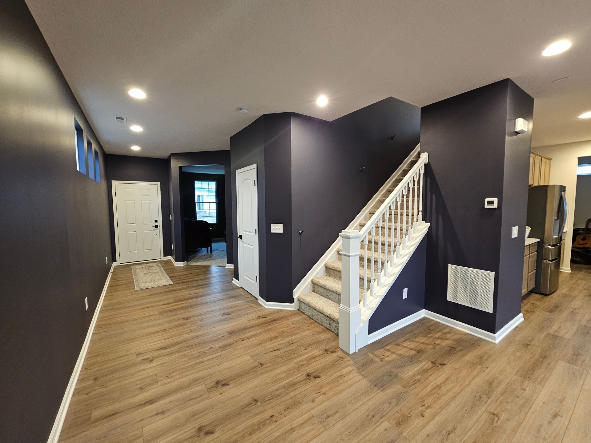 Modern entryway with dark navy painted walls and white trim – Grove City interior painting project. Promus Home Improvement