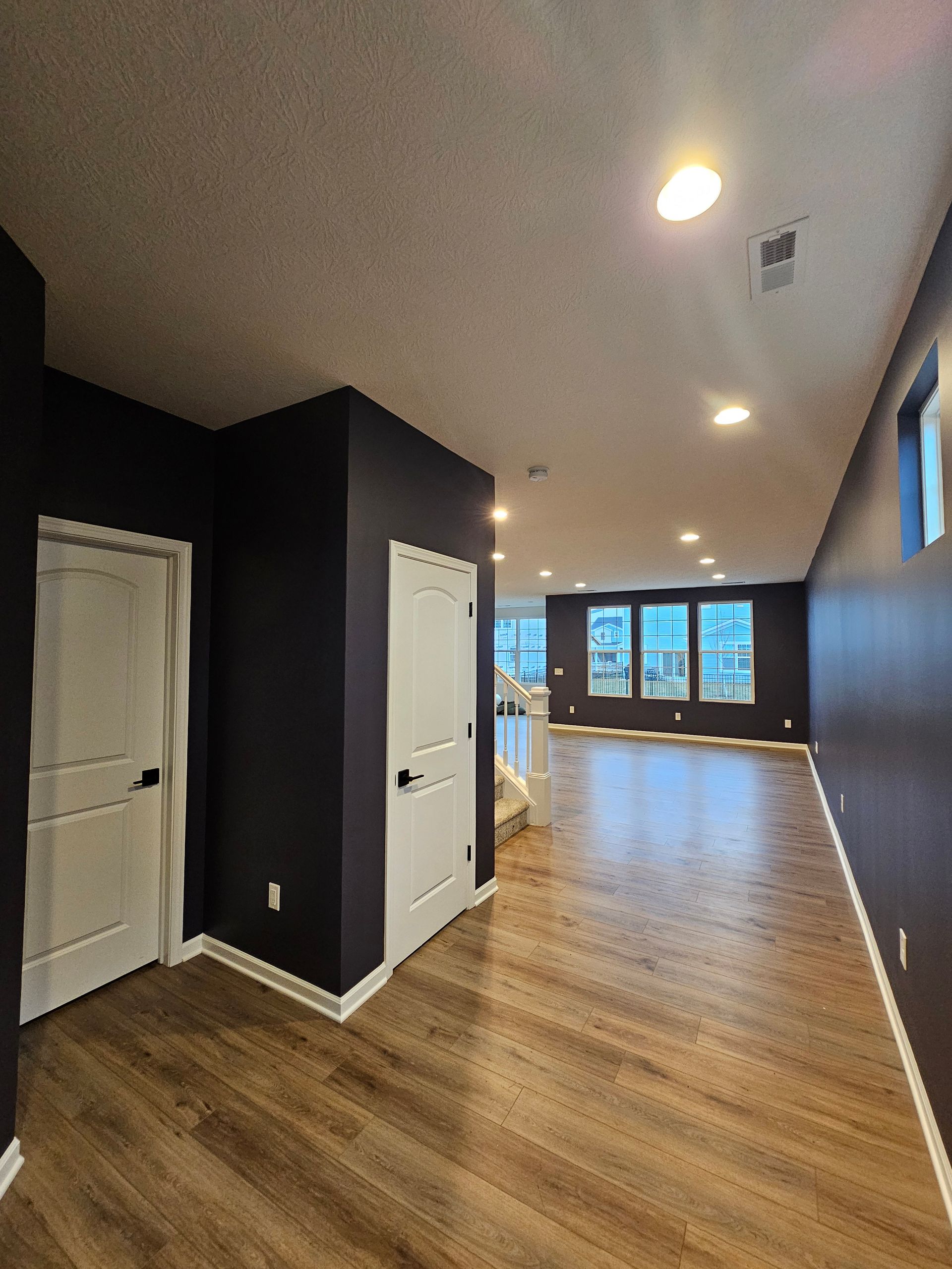 Modern entryway with dark navy painted walls and white trim – Grove City interior painting project. Promus Home Improvement