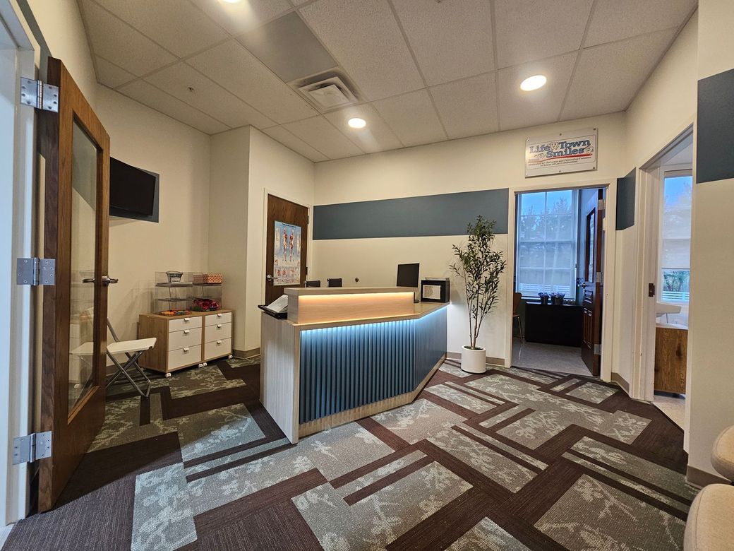 Reception area with desk, blue curtain, carpet, and an open door. New Albany commercial interior painting project. 