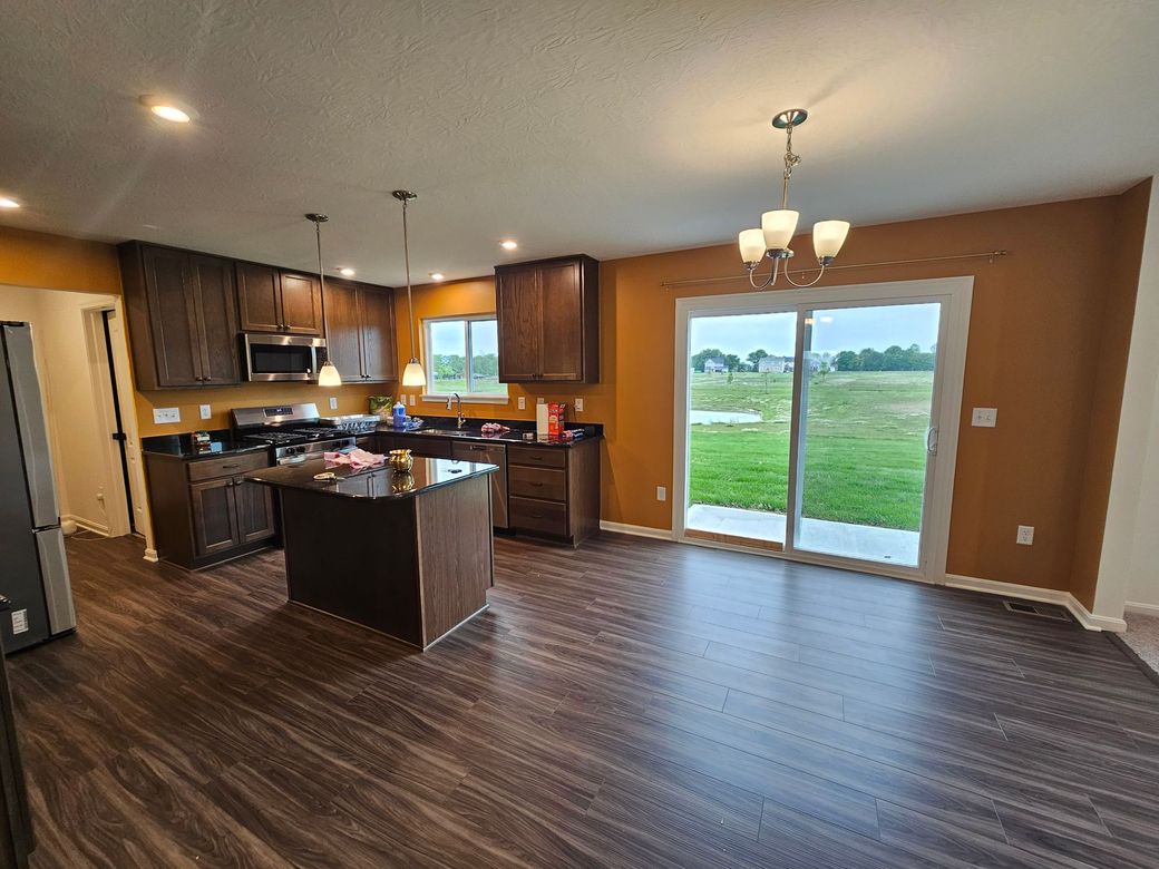 Modern kitchen with dark wood cabinets, island, and flooring, golden walls. Powel interior painting project. 