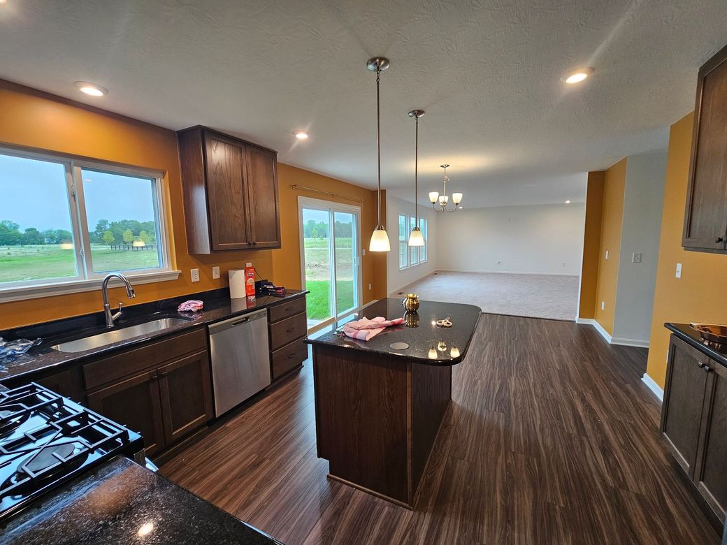Modern kitchen with dark wood cabinets, island, and flooring, golden walls. Powel interior painting project. 