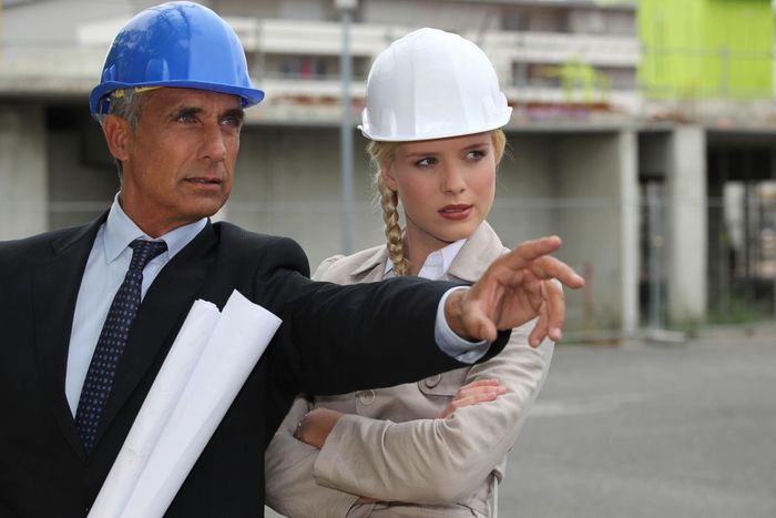 a man and a woman wearing hard hats