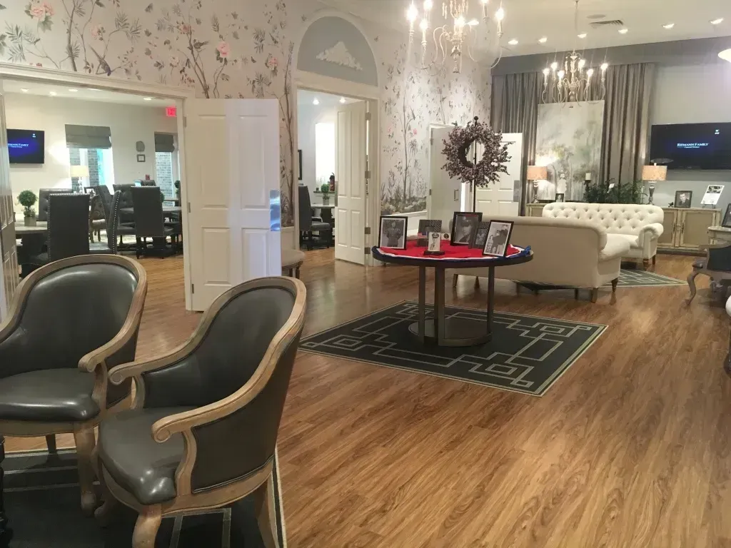 Elegant living room with two green chairs, a red coffee table, and bright wood floors