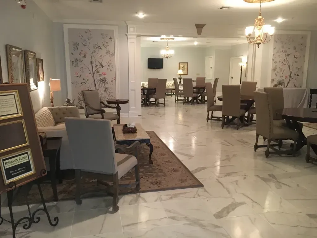 Elegant hotel lobby with marble floor, chandeliers, and seating areas around the room