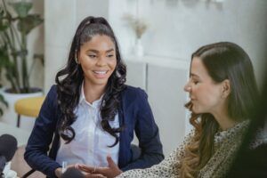 Two women smiling and talking in a bright office setting