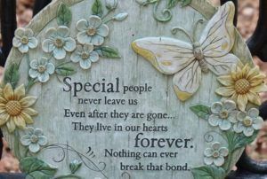 Decorative memorial plaque with flowers and quote about loved ones living forever in our hearts