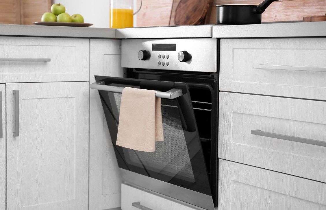 A Kitchen With a Towel Hanging From the Oven Door — Rob Fritsch Electrical in Wagga Wagga, NSW