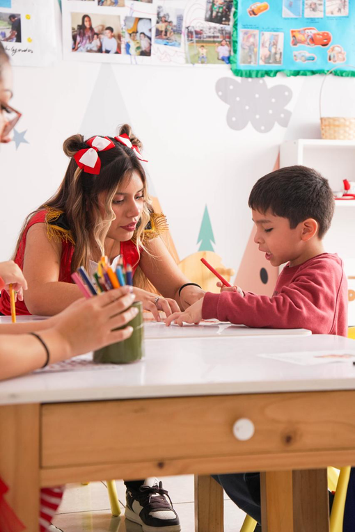 Profesional sanitario ayudando a un niño sentado en una consulta con paredes verdes
