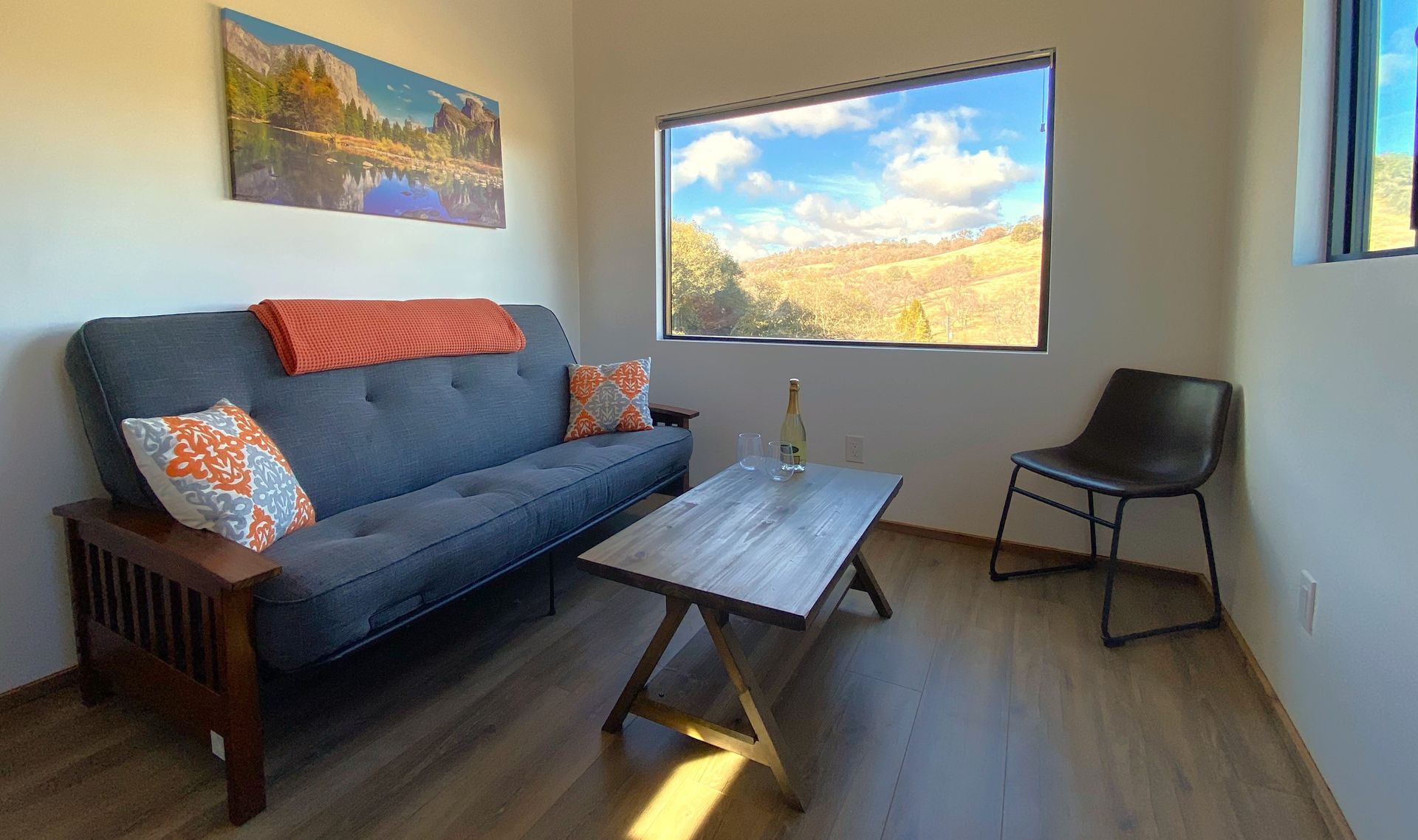 A living room with a futon , coffee table and chair.