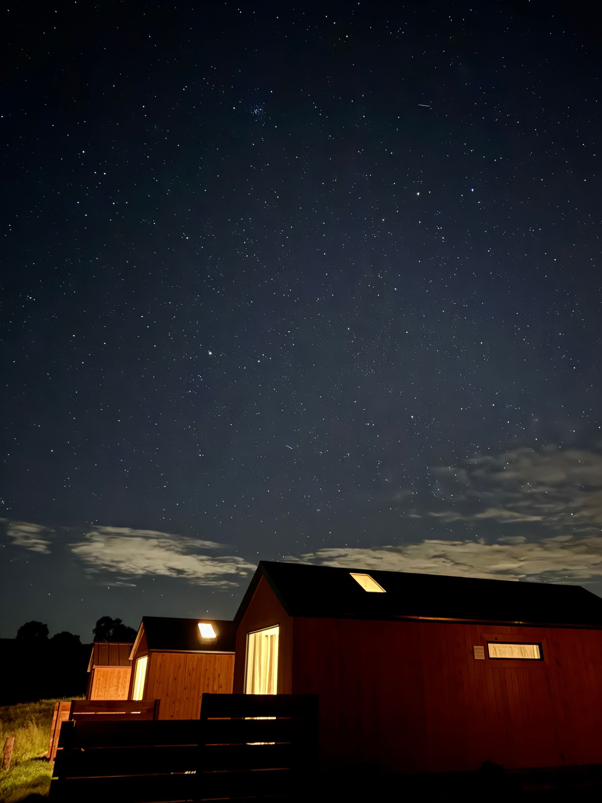 A house is lit up at night under a starry sky.