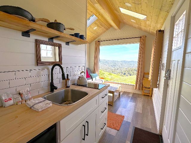 A kitchen in a small house with a sink and a window.