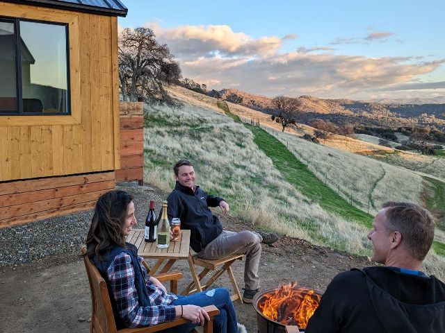 A group of people are sitting around a fire pit.