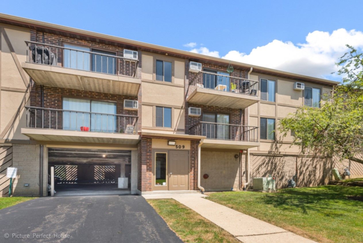 A large apartment building with balconies and a garage.