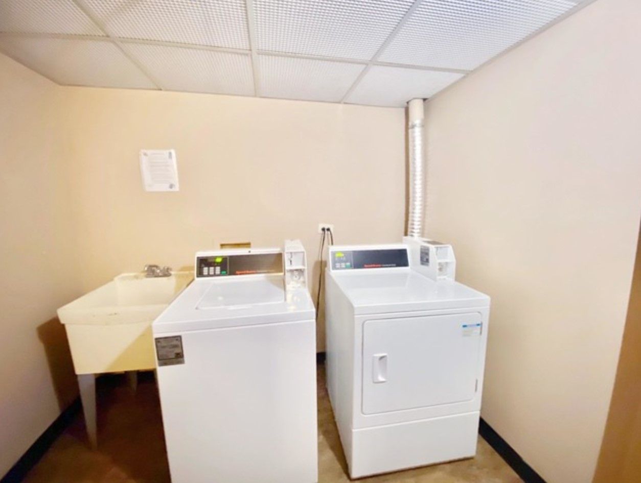 A laundry room with a washer and dryer and a sink.
