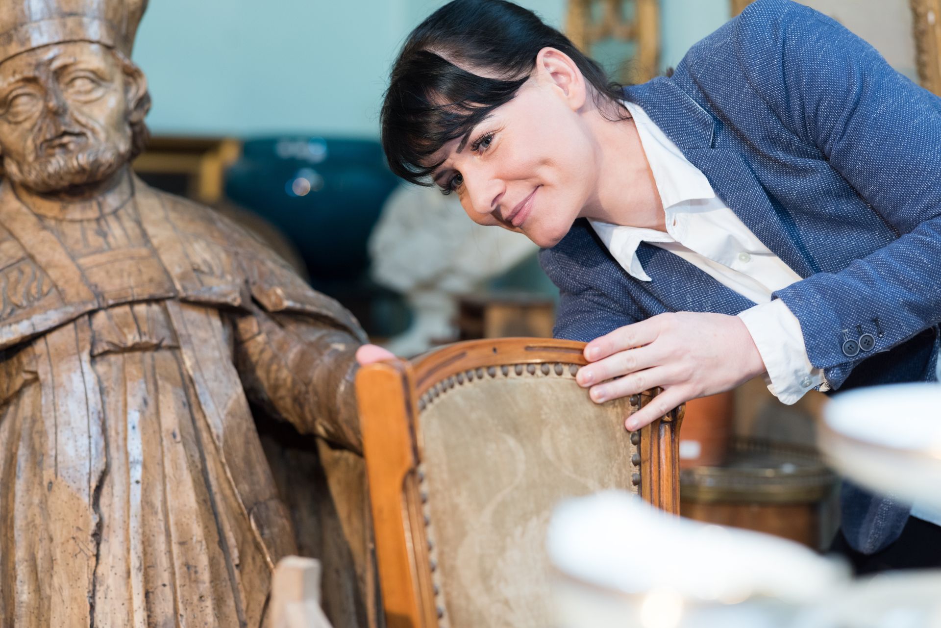 An antiques buyer inspecting a vintage chair.
