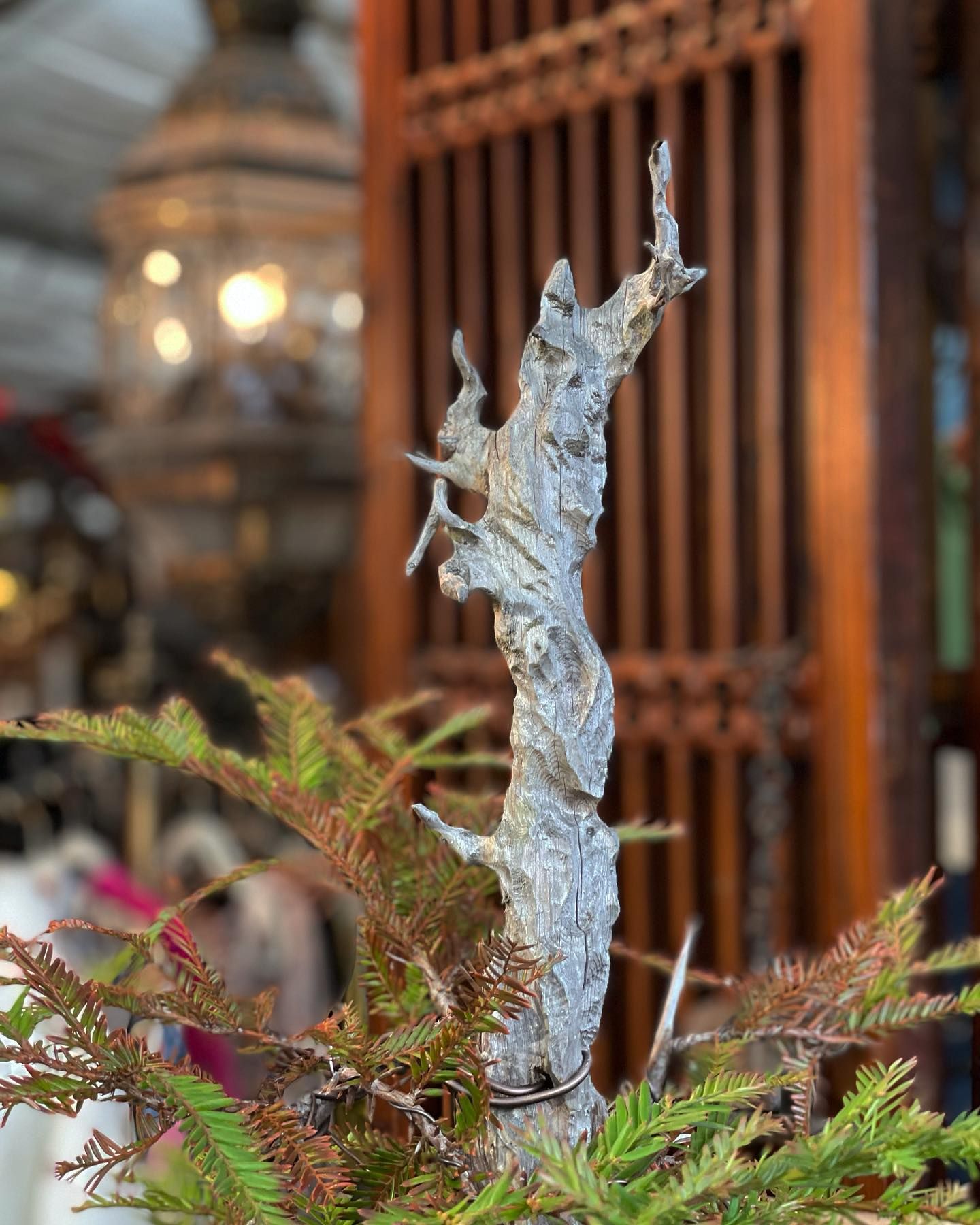 A small frosted branch ornament with colorful foliage in a warm indoor setting
