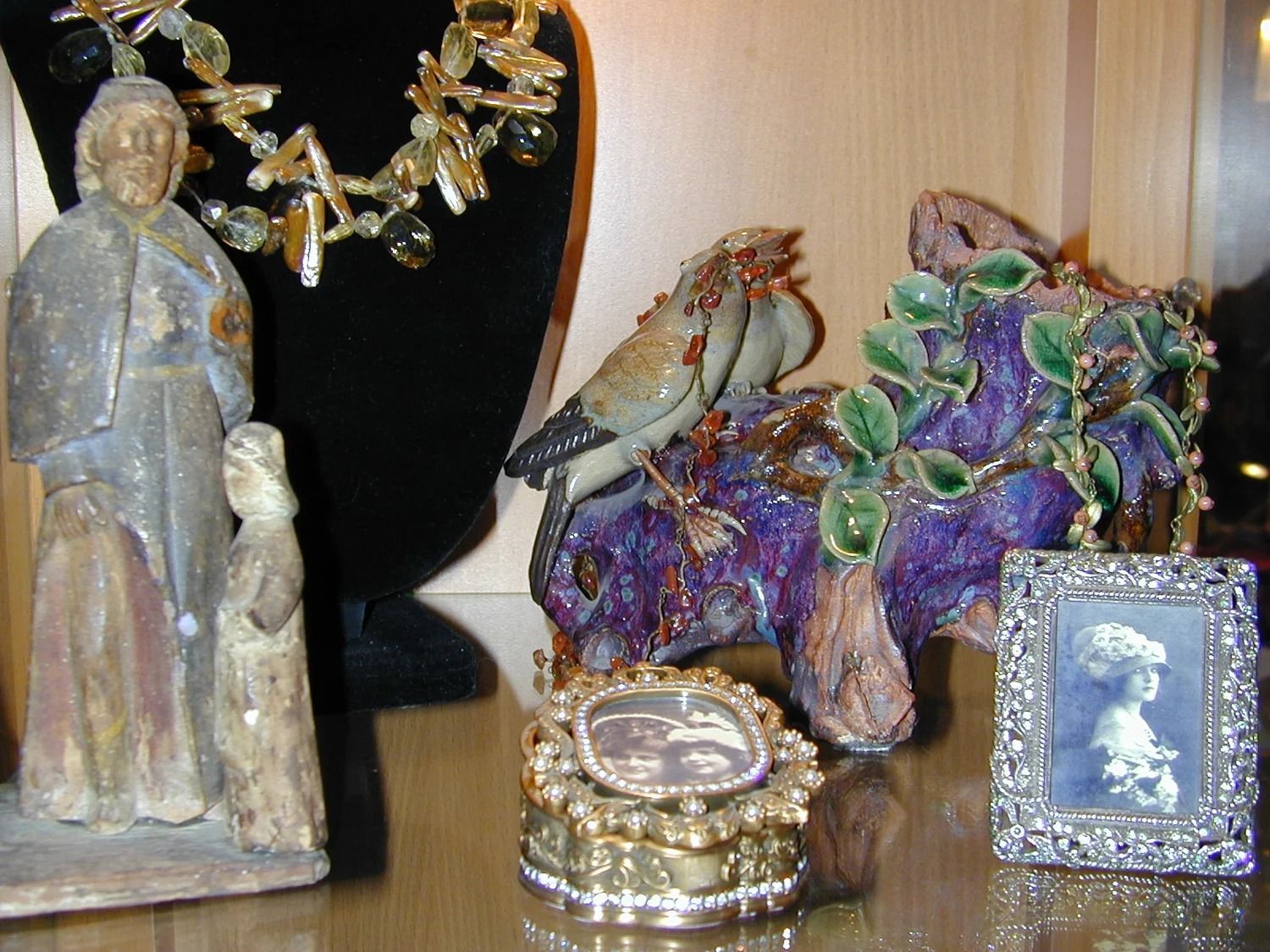 Decorative shelf with figurines, a jeweled box, and a purple-green mineral cluster