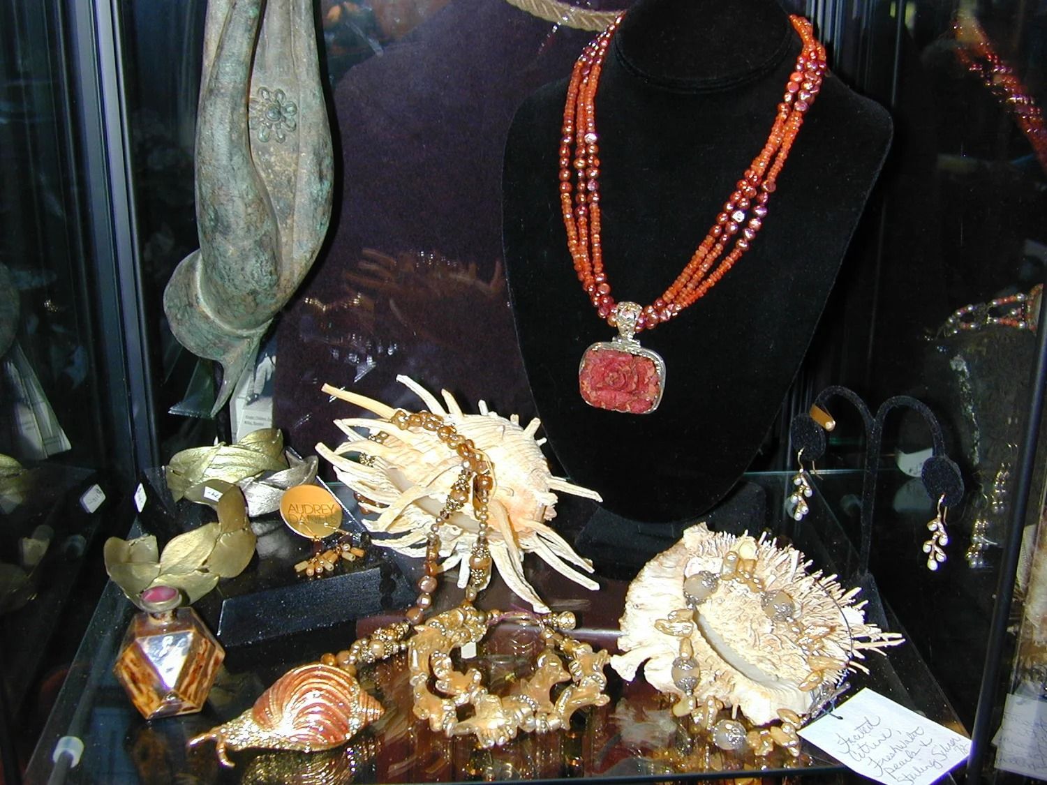 Jewelry display with necklace and brooches on black velvet stand