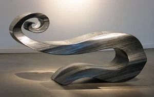 Abstract silver sculpture with flowing curved forms in a minimalist gallery-like setting