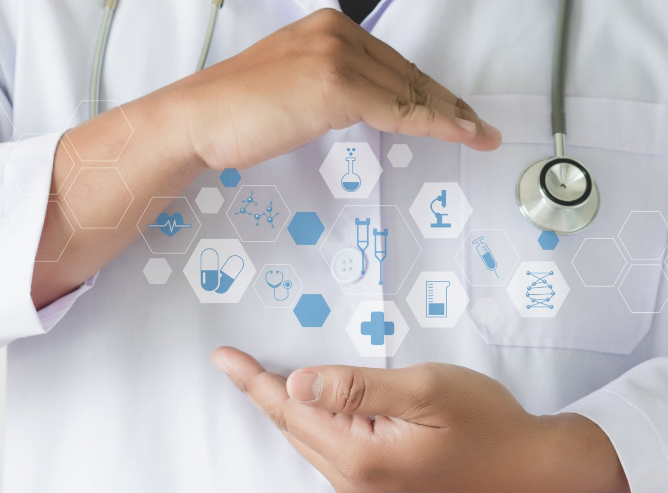 A doctor with a stethoscope around his neck is holding up a shield of medical icons