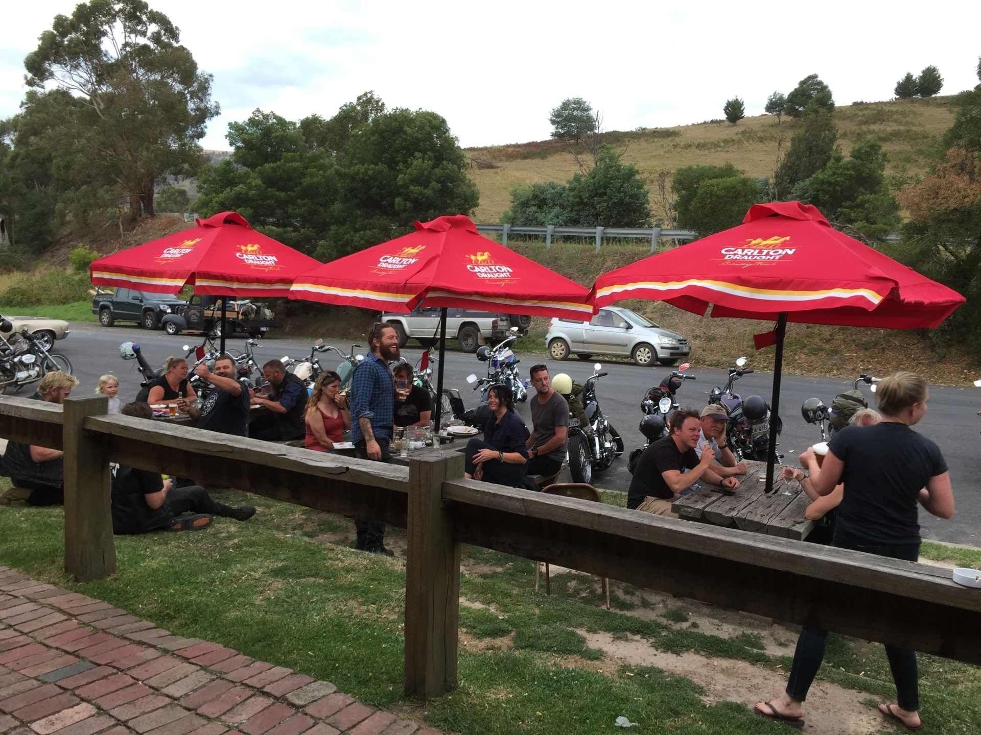 sitting areas with park tables under red umbrellas 