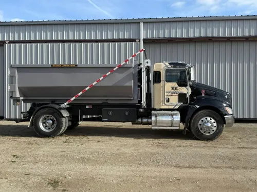 A dumpster is parked in front of a best buy store.