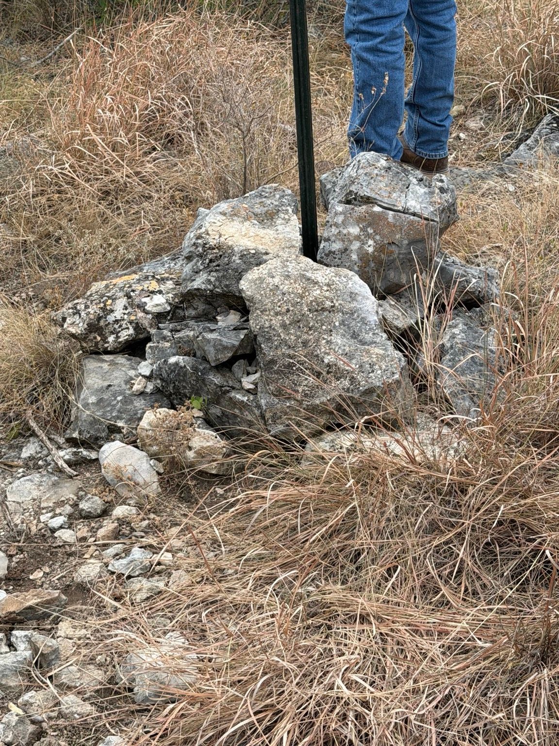 Survey rod at a stone boundary marker in the field