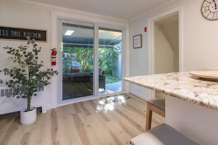 Bright modern kitchen with sliding glass doors opening to a leafy patio.