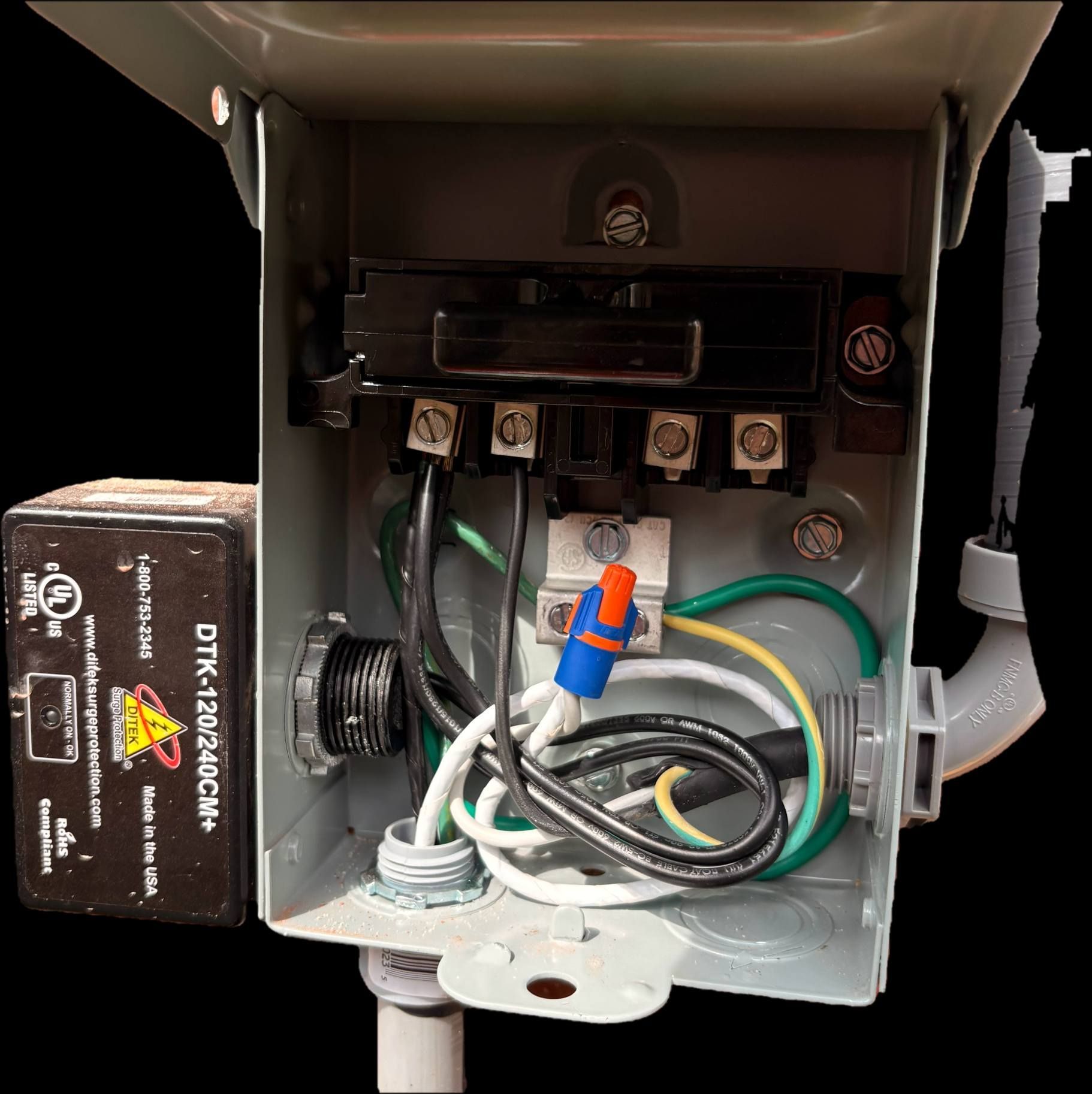 Open electrical control box with wires, terminals, and a battery pack inside.