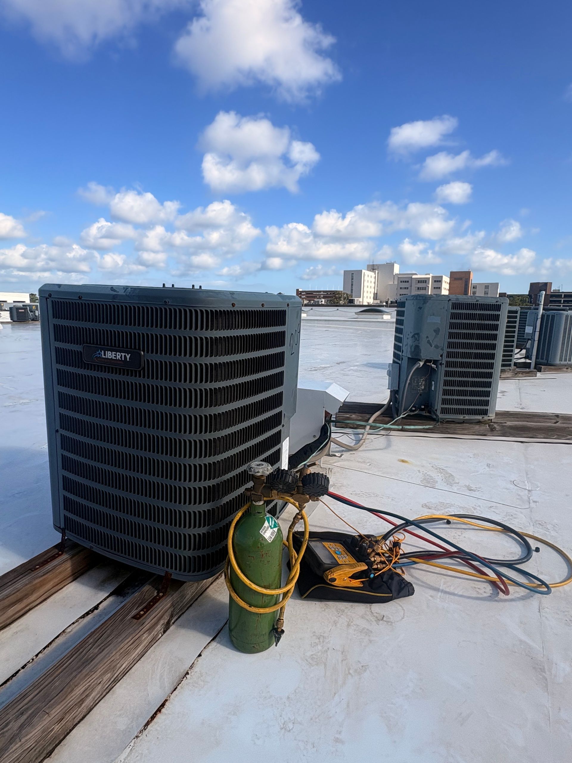 Air conditioning units with toolbox and gloves in backyard.