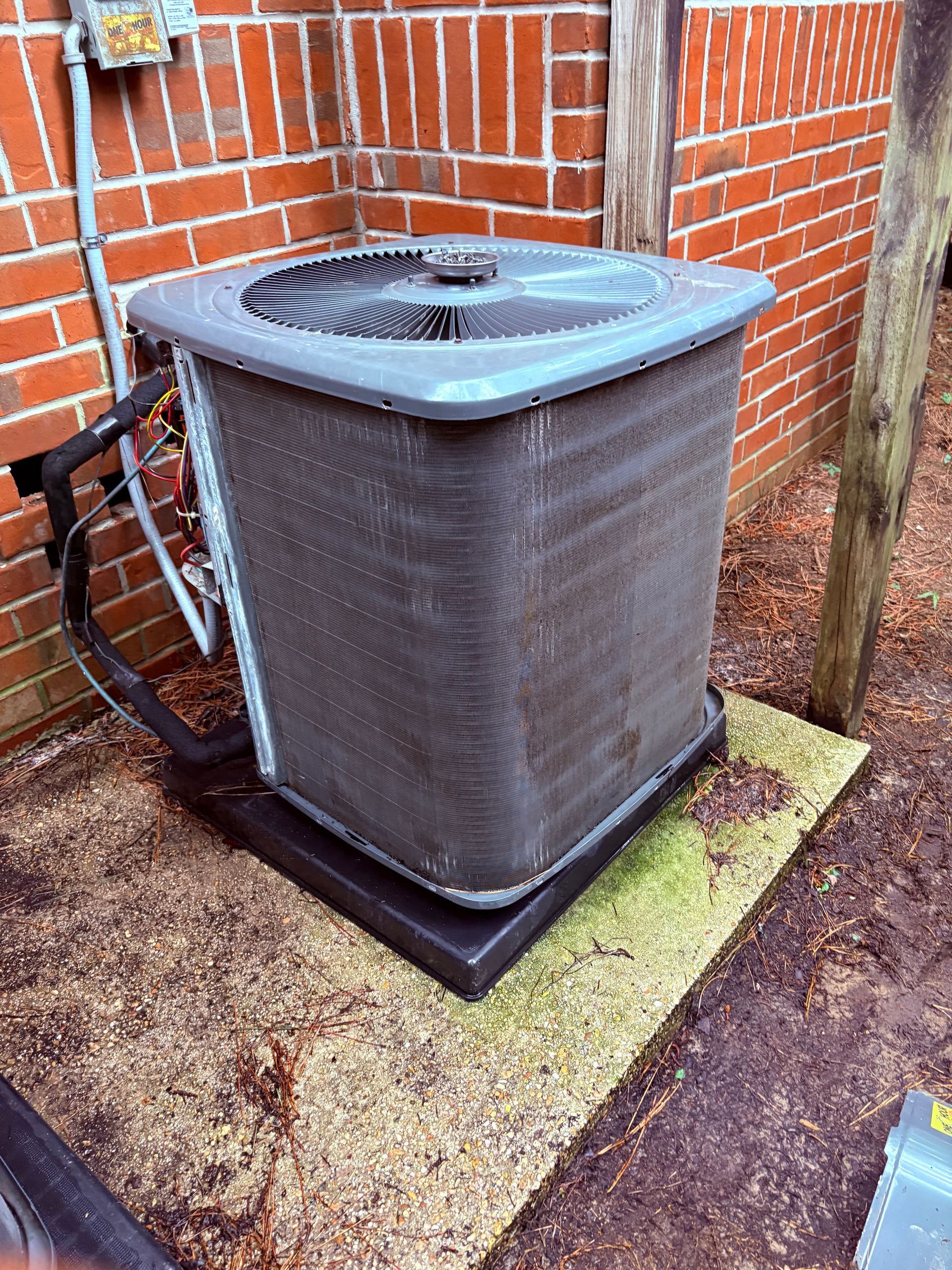 Air conditioning units with toolbox and gloves in backyard.