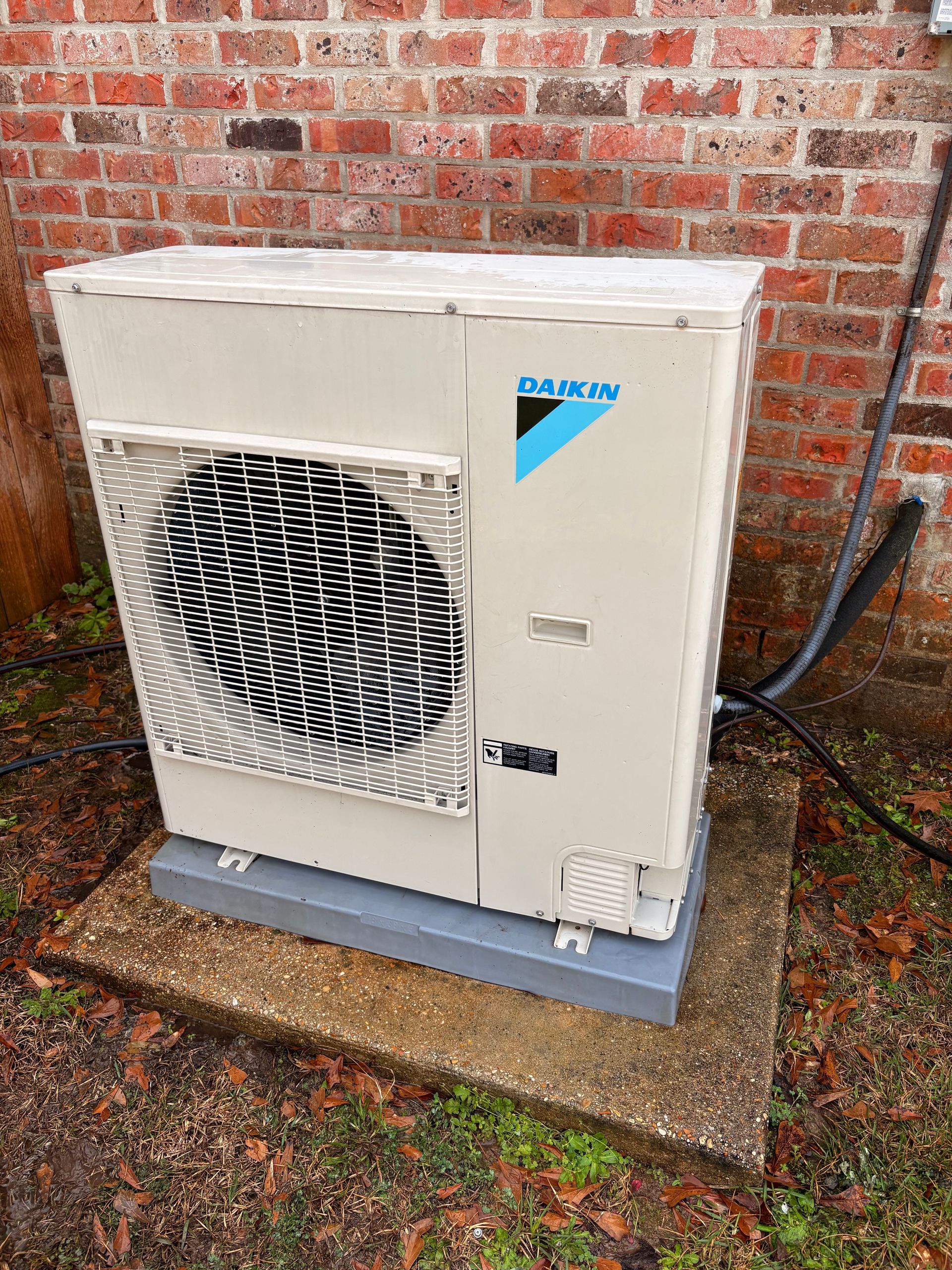 Air conditioning units with toolbox and gloves in backyard.