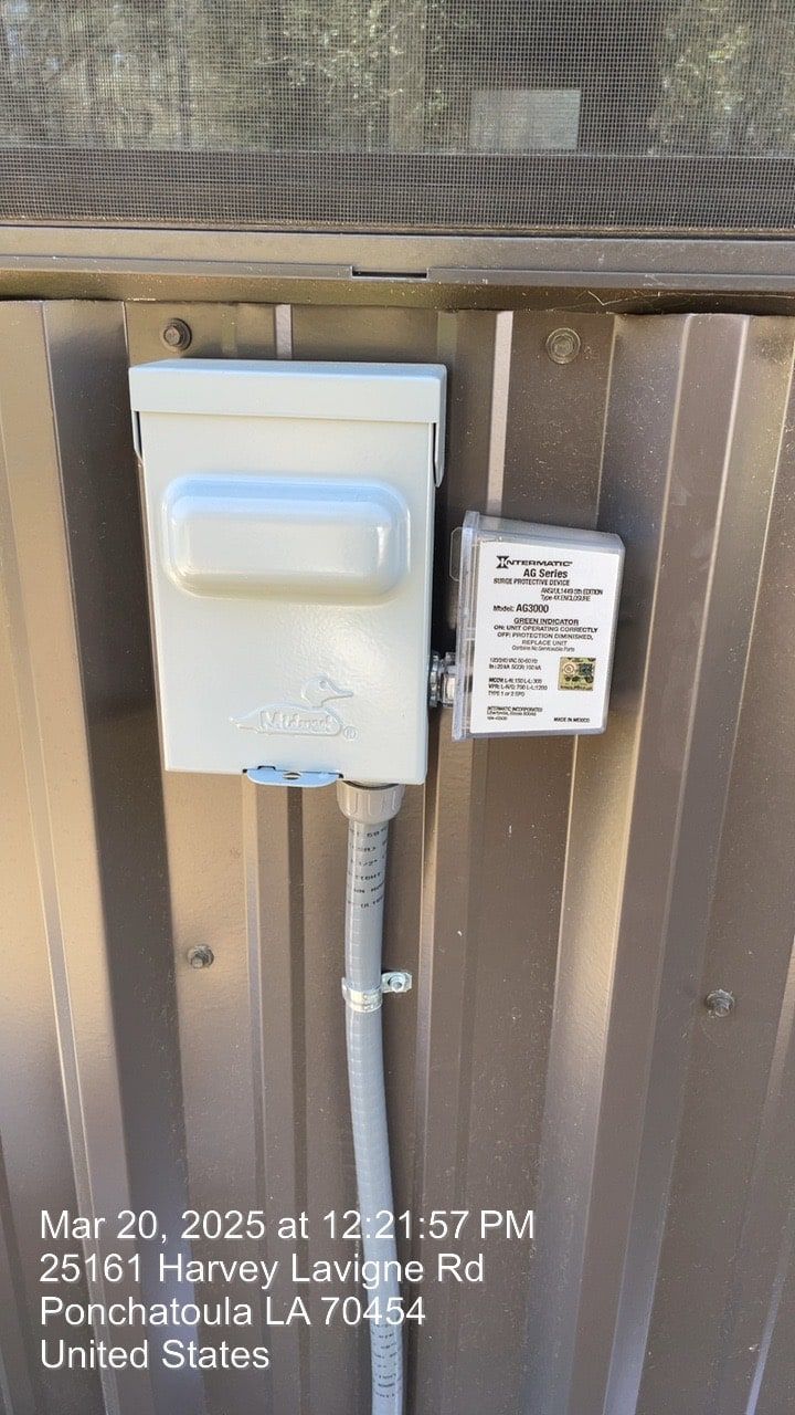 White electrical box and meter mounted on a wooden fence with a small warning label.