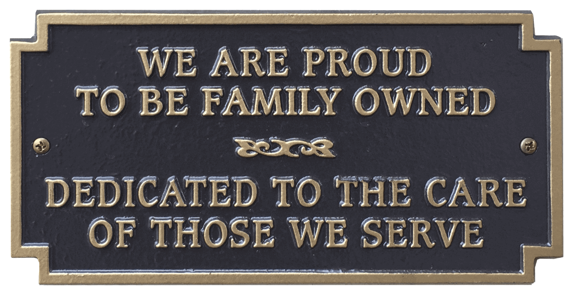 Bronze plaque with gold lettering: "We are proud to be family owned, dedicated to the care of those we serve."