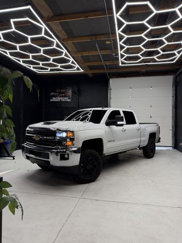 Black GMC Sierra truck parked on wet asphalt.
