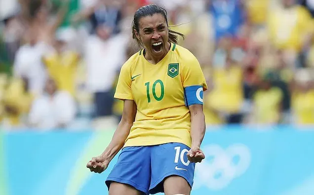 A female soccer player is celebrating a goal on the field.