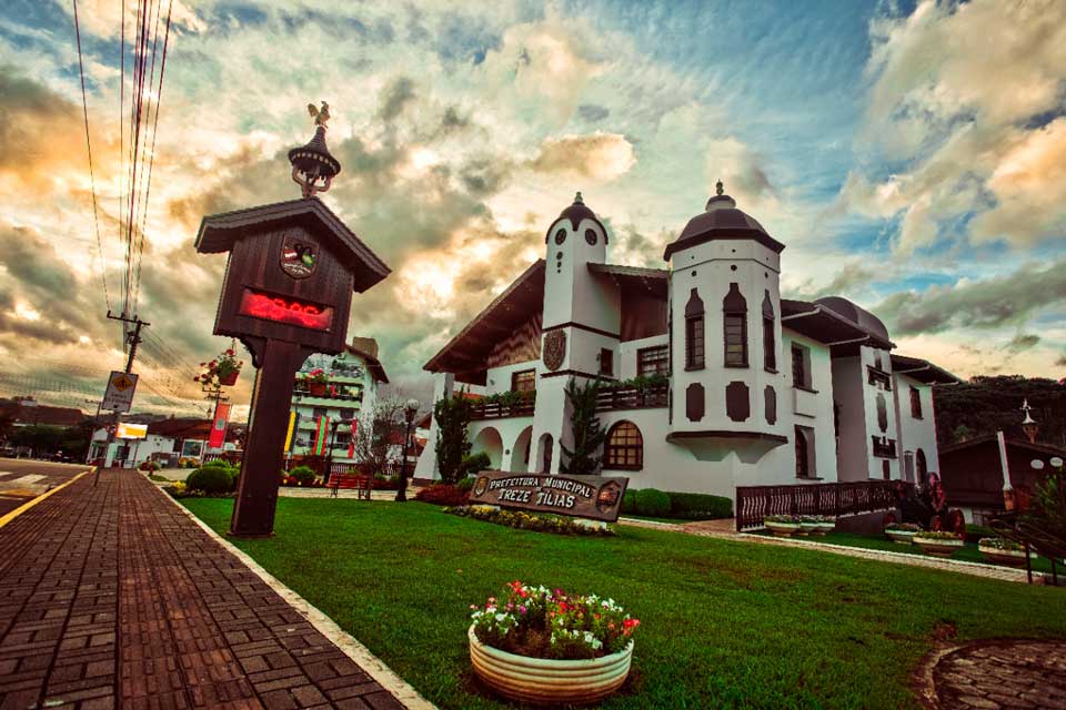 A large white building with a clock tower in front of it.