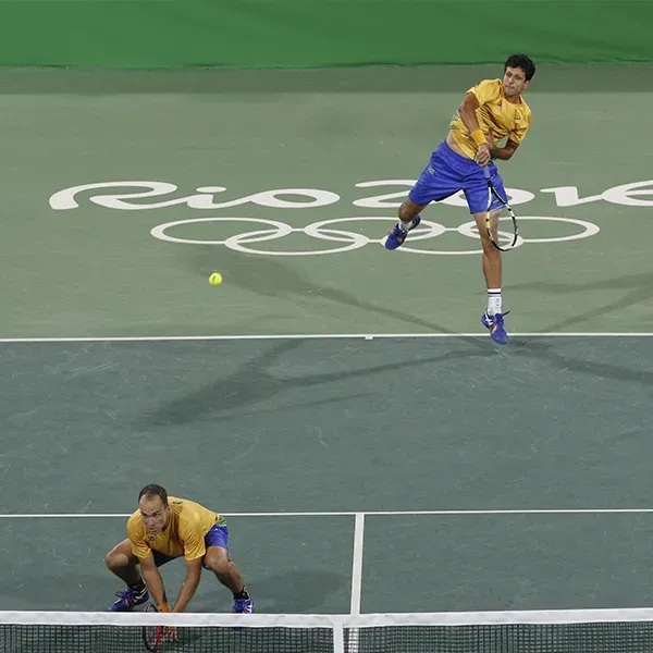 Two men are playing tennis on a court that says rio 2016