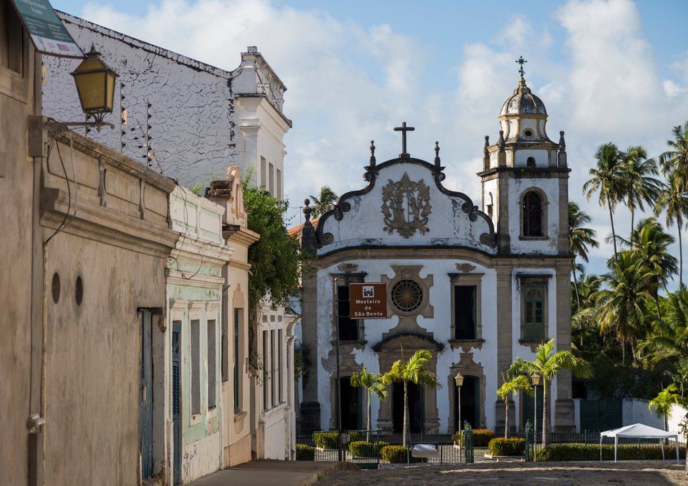 Une église au bout d'une rue pavée lapée avec un plus vieux bâtiment autour