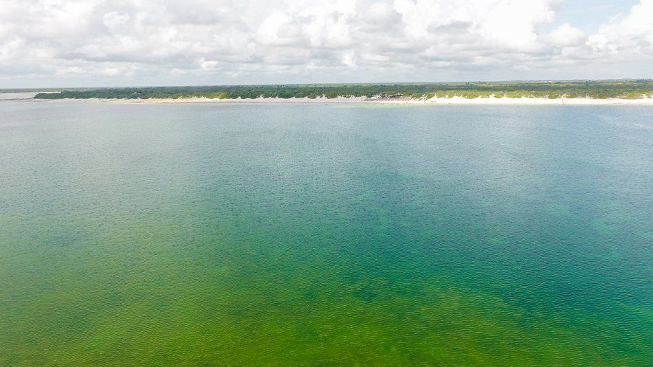 An aerial view of a large body of water with a beach in the background.