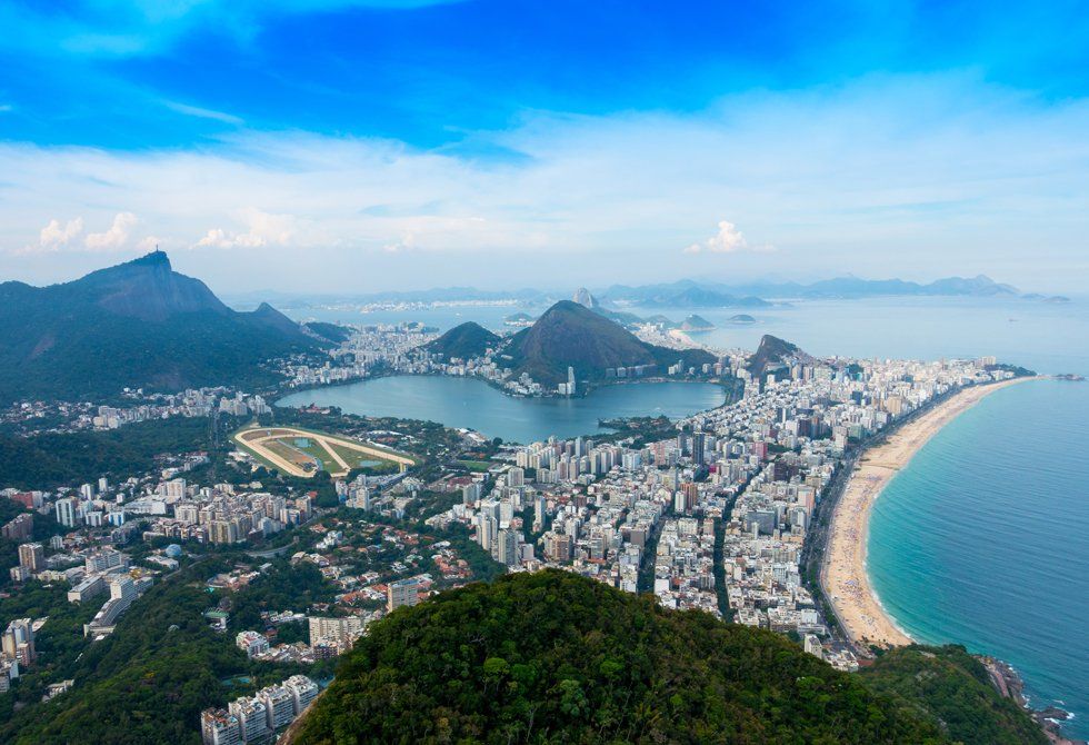 An aerial view of a city with a beach and mountains in the background.