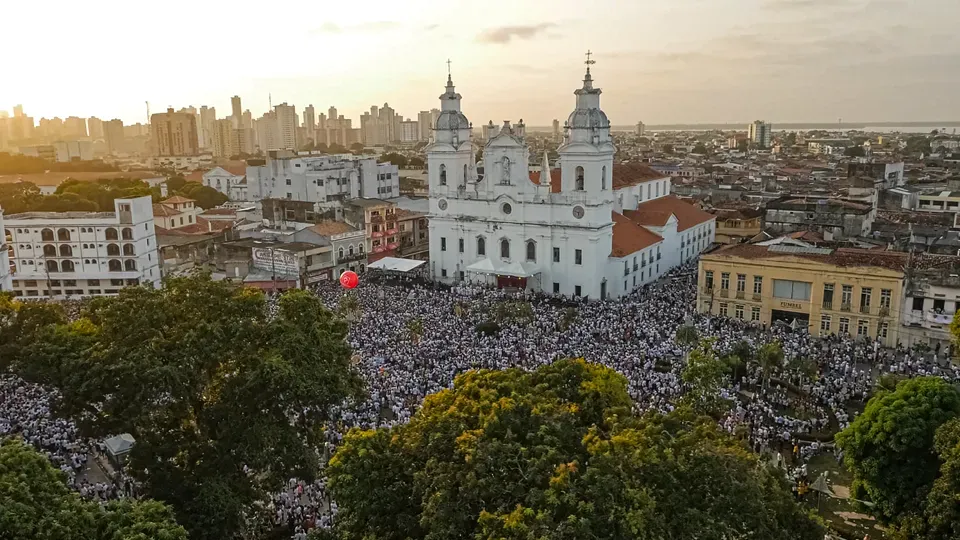 An aerial view of a large church surrounded by trees in a city.
