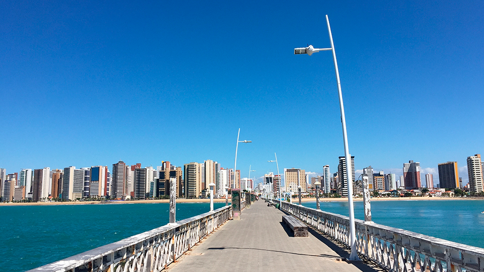 A pier overlooking a body of water with a city skyline in the background.