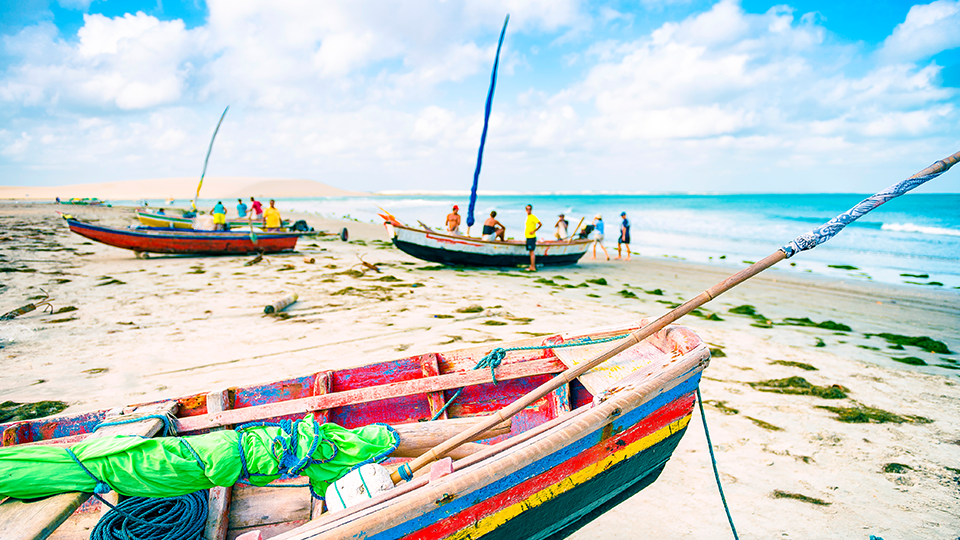 Barcos atracados en una playa A group of boats are sitting on top of a sandy beach.