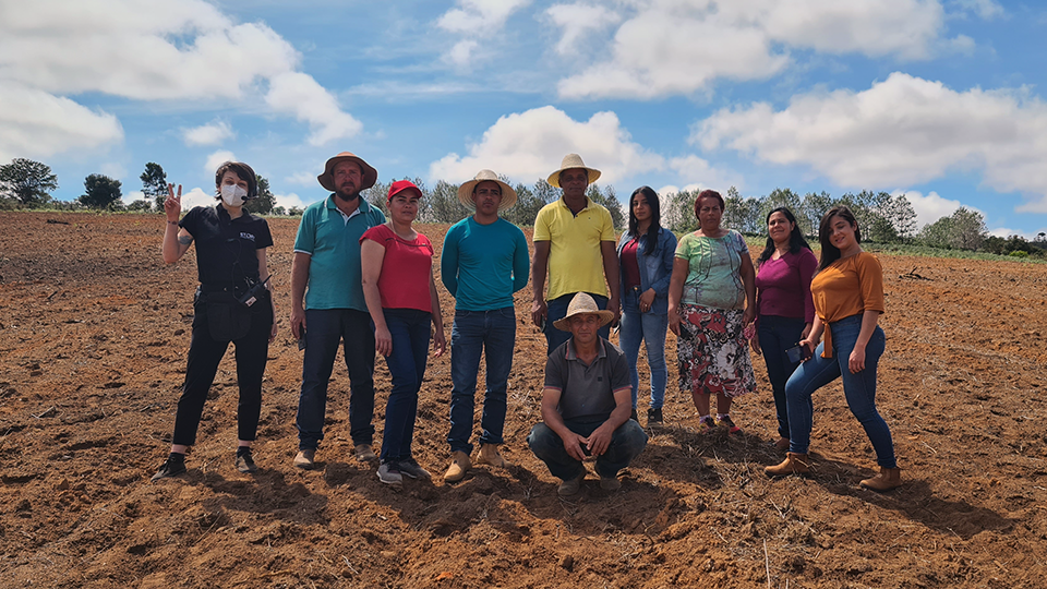 Farm workers along with the Story Producitons crew A group of people are posing for a picture in a dirt field.